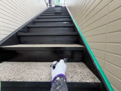 柏市の集合住宅の階段をファインパーフェクトトップで塗装作業中。