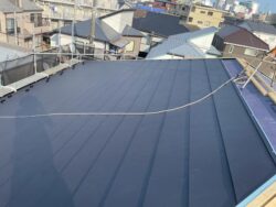 柏市の集合住宅の屋根にスーパーガルテクトを取り付け作業中