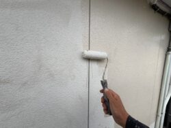 柏市の集合住宅の窯業系サイディング2階外壁を下塗りする作業中