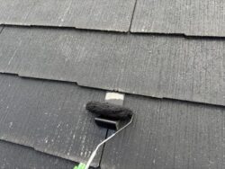 屋根の雪止めを錆止めで塗装している様子